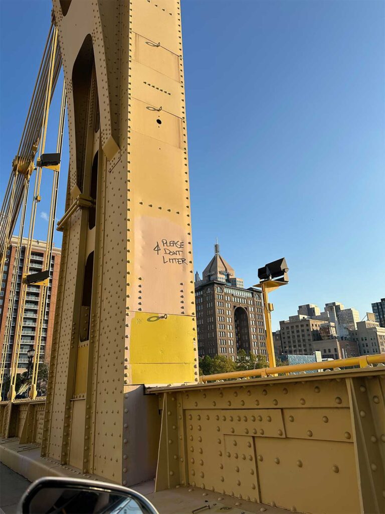 Pittsburgh PA's Roberto Clemente Bridge tagged with graffiti, "Please Don't Litter". 